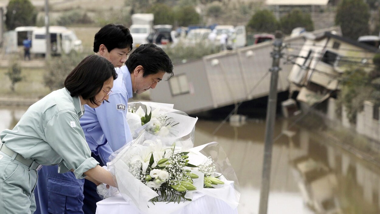 Le premier ministre japonais Shinzo Abe, au centre, offre des fleurs pour les victimes à Kurashiki, préfecture d'Okayama, dans l'ouest du Japon. Le premier ministre japonais Shinzo Abe, au centre, offre des fleurs pour les victimes à Kurashiki, préfecture d'Okayama, dans l'ouest du Japon.