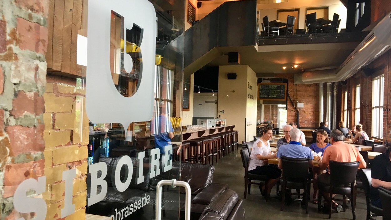 Des clients prennent une bière à l'intérieur de la succursale du Siboire Dépôt, à Sherbrooke.
