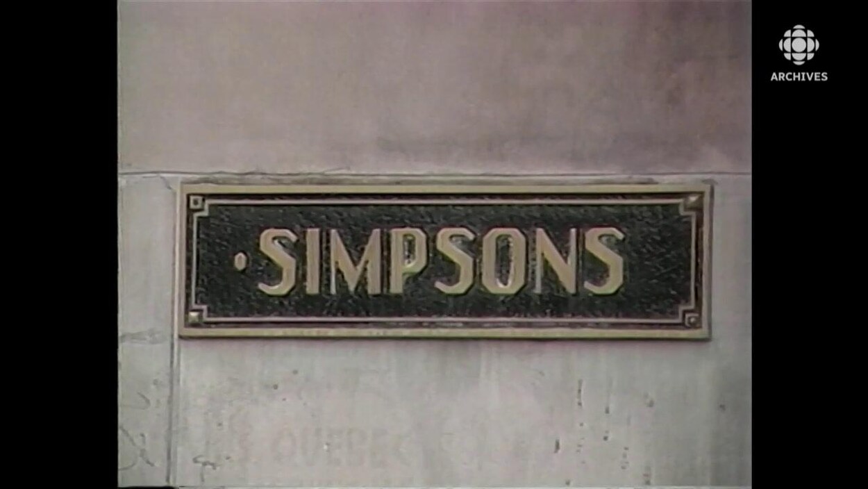 Plaque de métal avec le nom Simpsons encastrée sur l'édifice Simpson de la rue Sainte-Catherine, à Montréal.