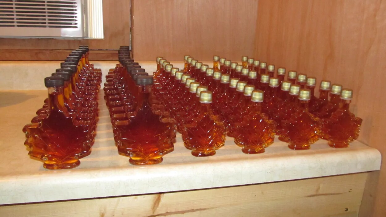 Des bouteilles de sirop d'érable en forme de feuille d'érable.