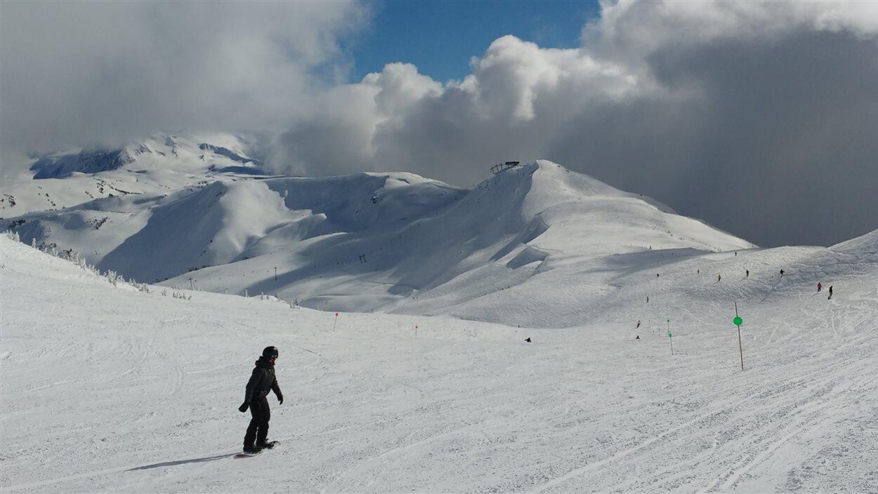 Un planchiste évolue le long d'une piste à Whistler en Colombie-Britannique