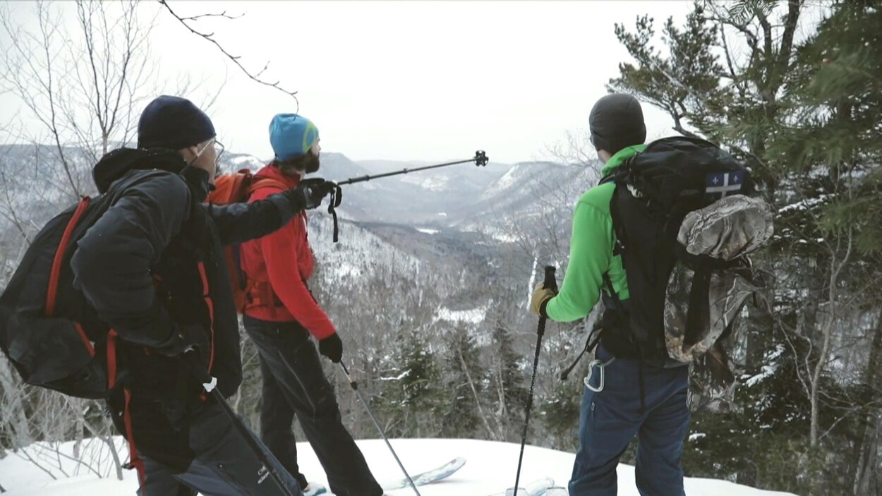 Skieurs au sommet d'une montagne regardent l'horizon