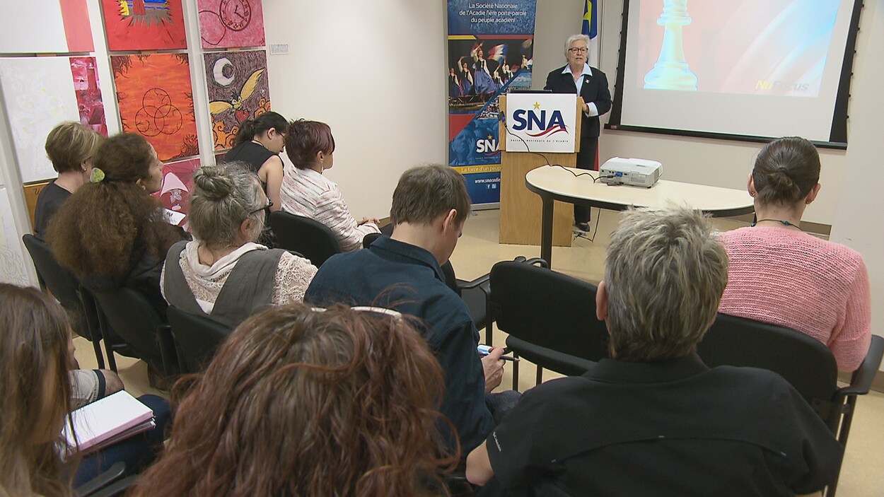Des gens assis dans une salle assistent au lancement Des gens assis dans une salle assistent au lancement
