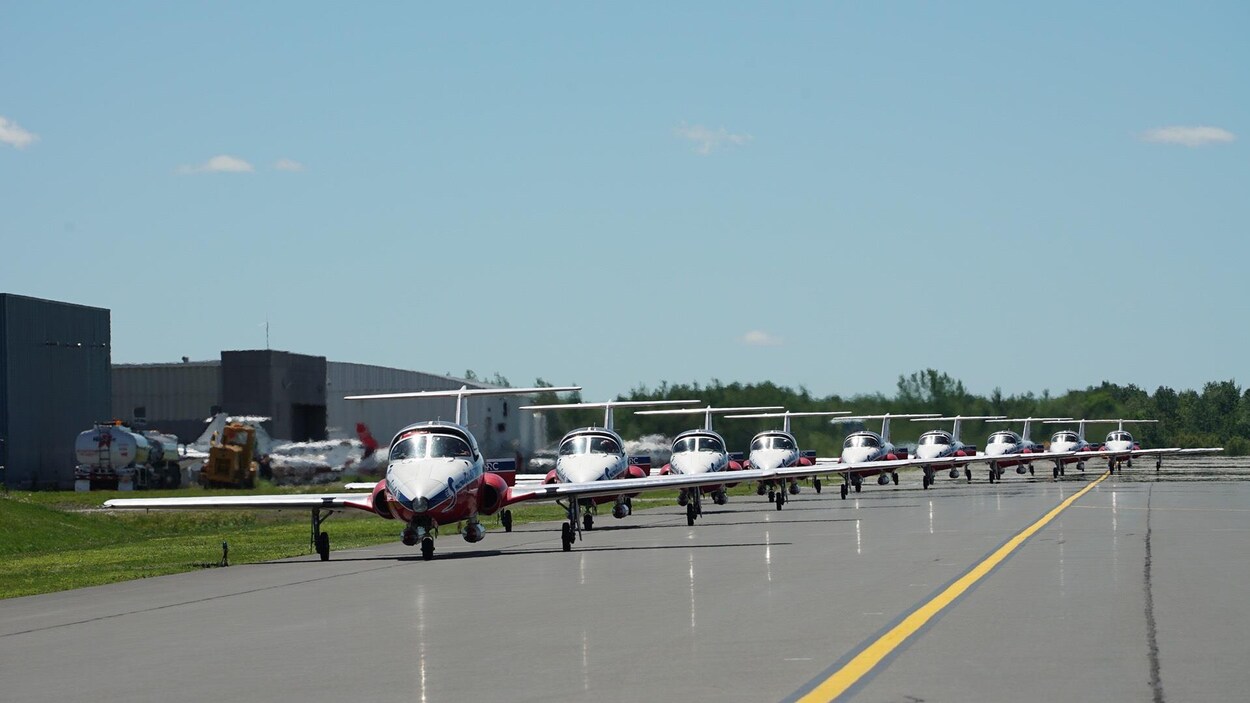 Plusieurs avions des Snowbirds sur une piste d'atterrissage.