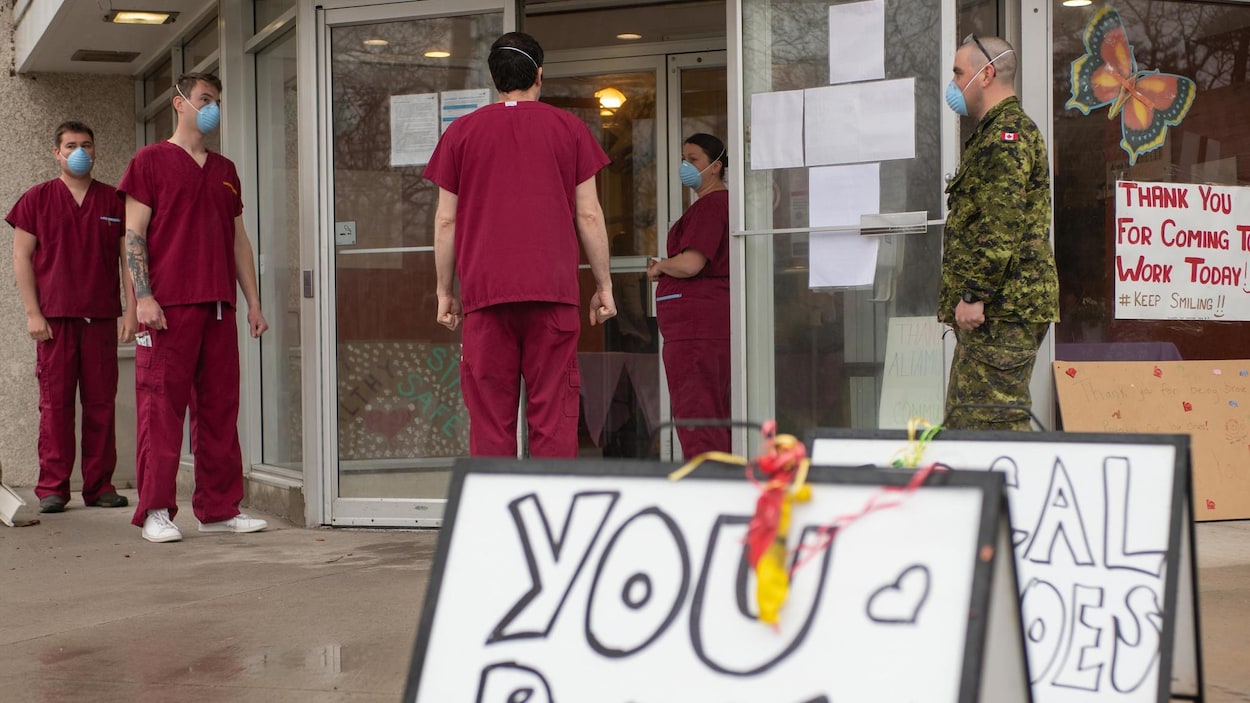 Des soldats en uniform bourgogne attendent d'entrer dans le centre de soins.