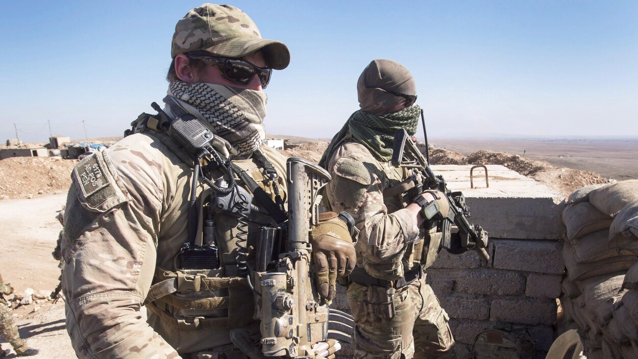Deux soldats montent la garde dans une position renforcée dans le désert.