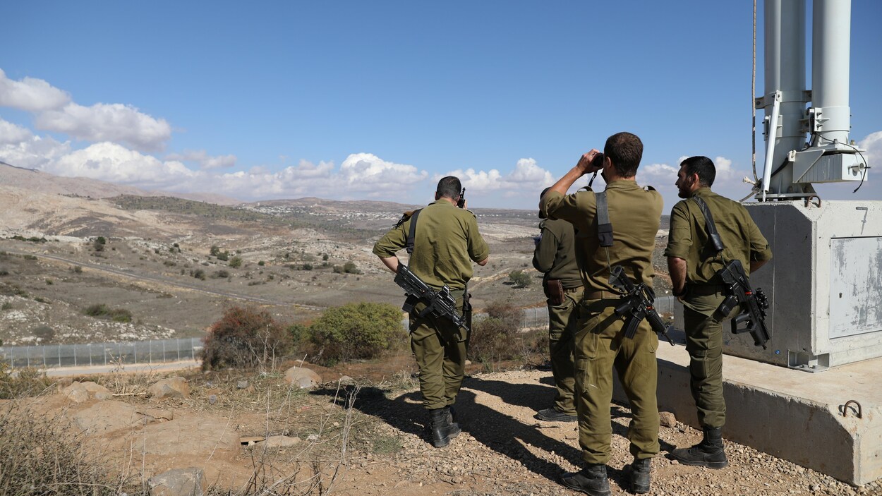 Quatre soldats israéliens regardent l'horizon depuis le plateau du Golan, qui surplombe le reste du territoire syrien.