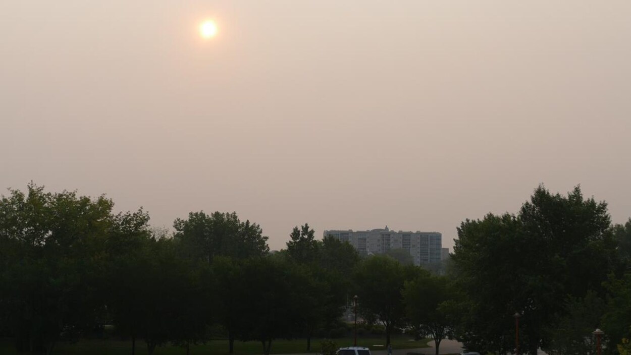 Le soleil est difficilement visible derrière la fumée des feux de forêt à Winnipeg Le soleil est difficilement visible derrière la fumée des feux de forêt à Winnipeg