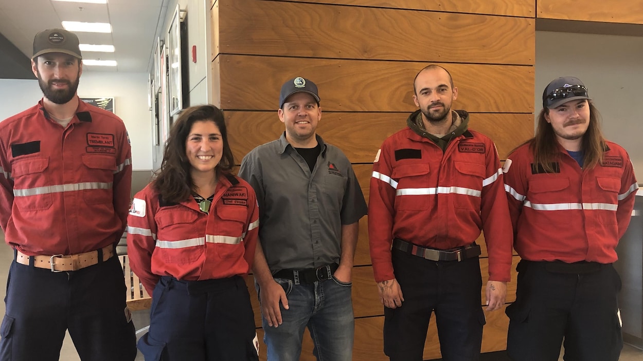 Cinq employés de la SOPFEU posent côte à côte à l'aéroport de Val-d'Or.