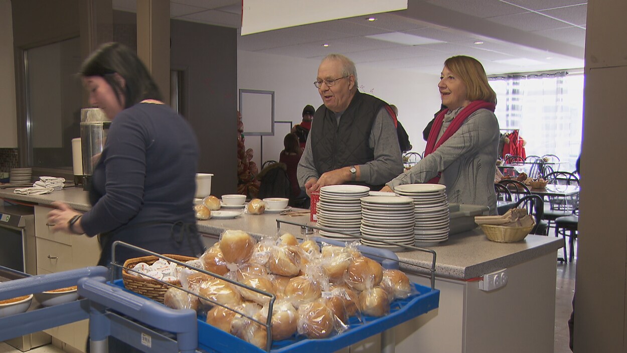Deux personnes sont au comptoir d'une soupe populaire.