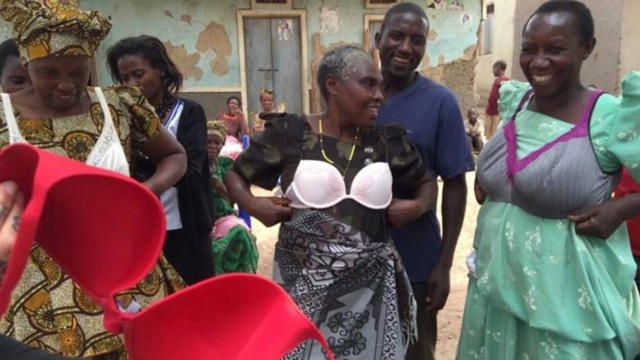 Des femmes africaines sourient en essayant des soutiens-gorges par-dessus leur vêtement.