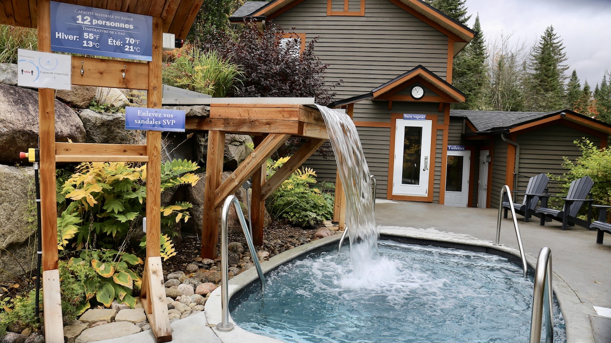 Une petite piscine extérieure près d'un pavillon dans un environnement apaisant, et une chute qui coule dans l'eau