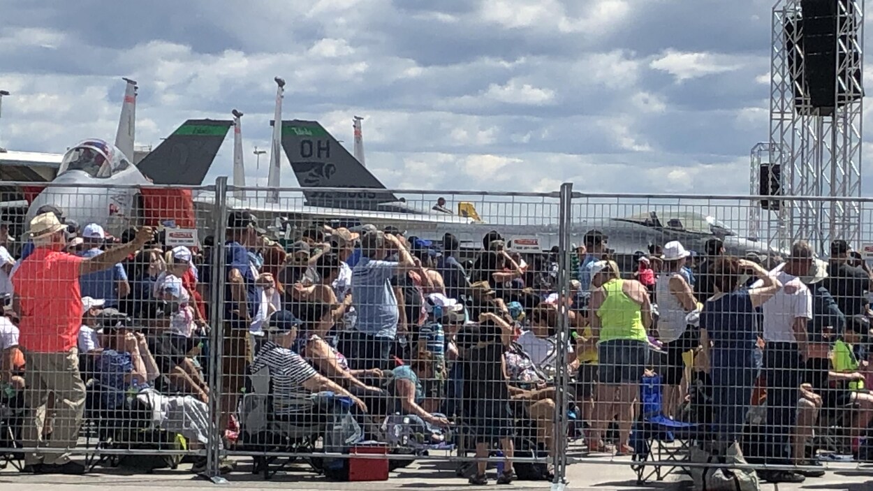 Une foule assiste à une démonstration aérienne.