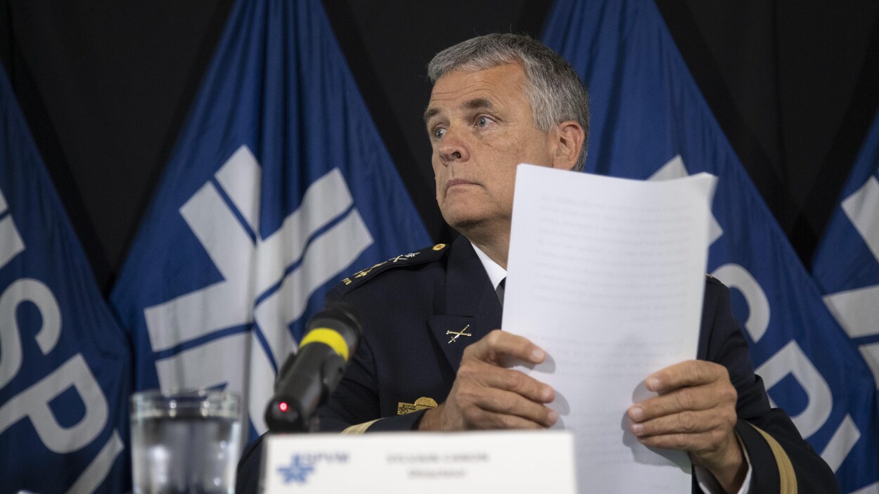 Sylvain Caron, assis, tient des feuilles dans ses mains.