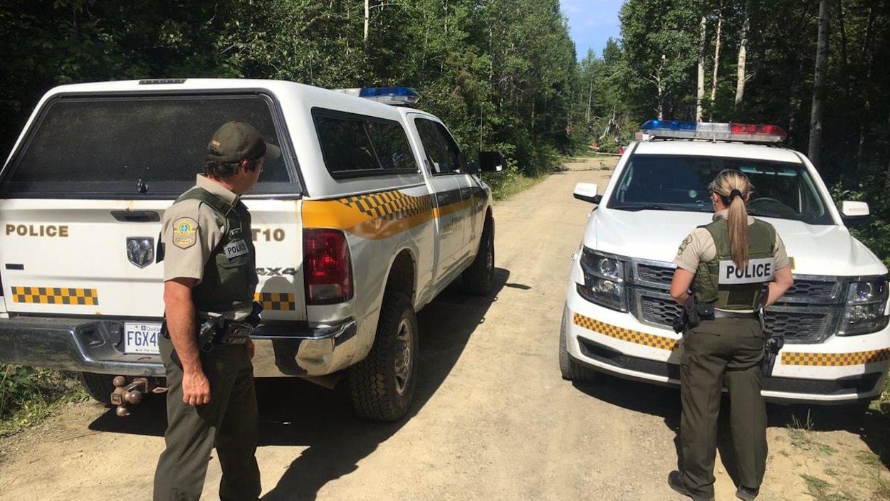 Les policiers bloquent le chemin d'accès au campement. Les policiers bloquent le chemin d'accès au campement.