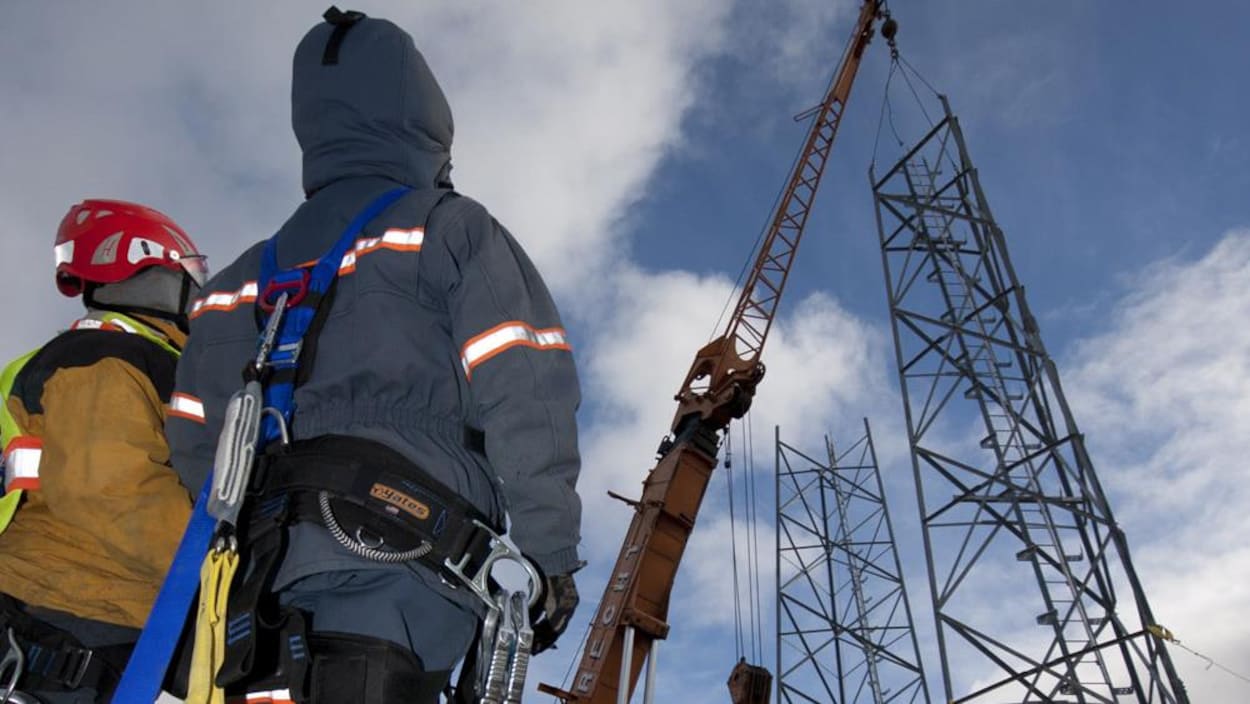 Des employés de SSi Canada devant des installations de télécommunications.
