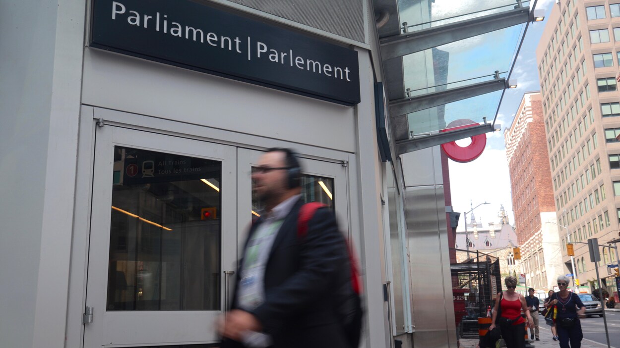 Un piéton circule devant la station Parlement du train léger d'Ottawa.
