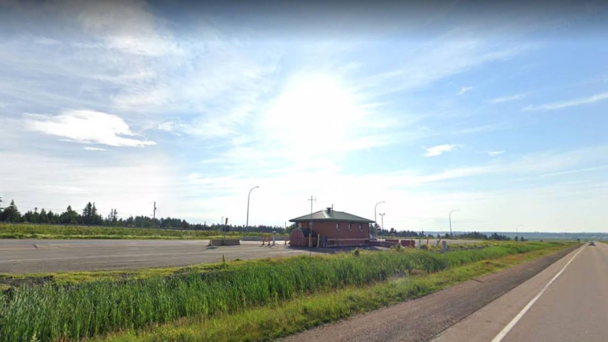 Une petite construction en briques entre deux voies de l'autoroute.