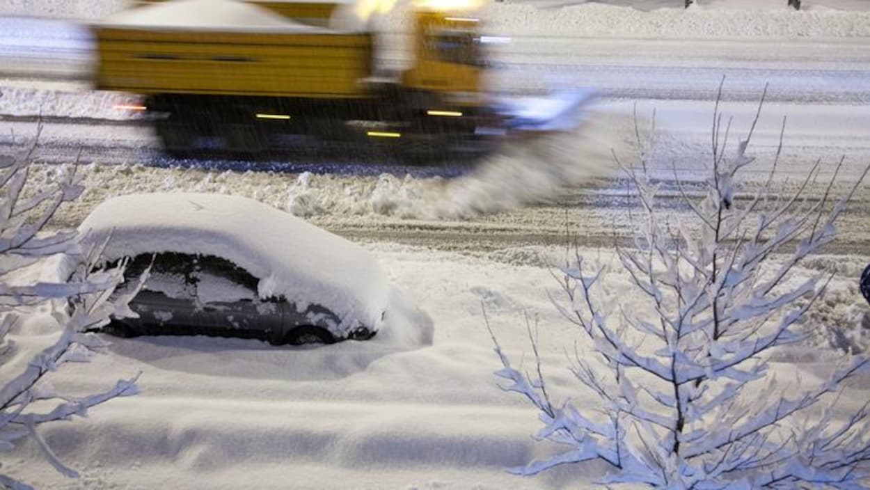 Un auto stationnée dans la rue la nuit.