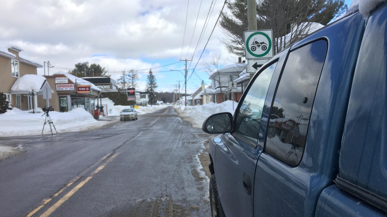 Une voiture est stationnée en bordure d'une rue.
