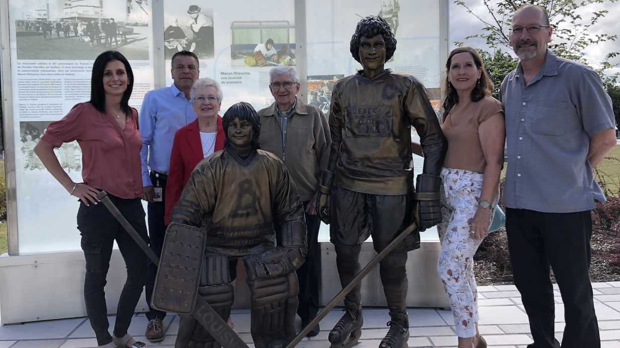 Manon Rhéaume, Patrick Dom et la famille de Sylvain Côté entourent la statue de bronze en hommage au tournoi peewee. 