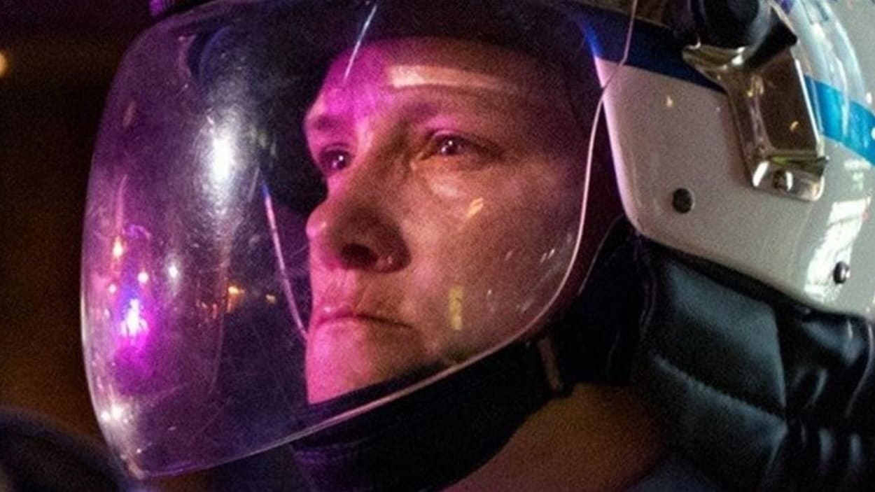 Plan rapproché de la policière avec son casque.