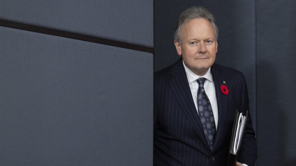 M. Poloz, qui porte le coquelicot à la boutonnière, tient un cahier noir dans ses mains.