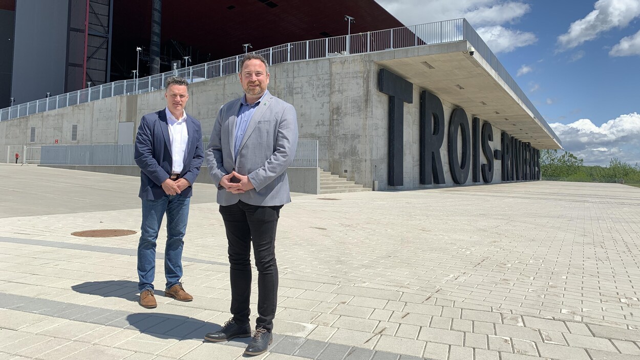 Deux hommes en veston devant l'Amphithéâtre Cogeco.