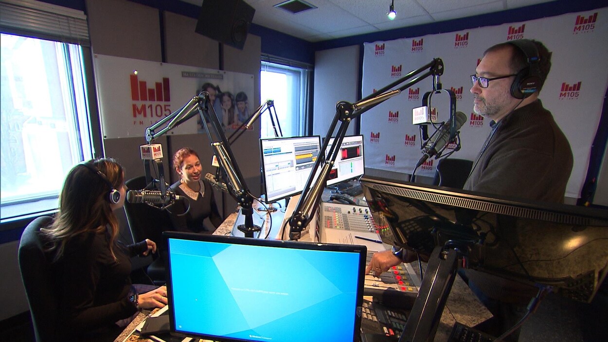 Un studio de radio avec trois animateurs.