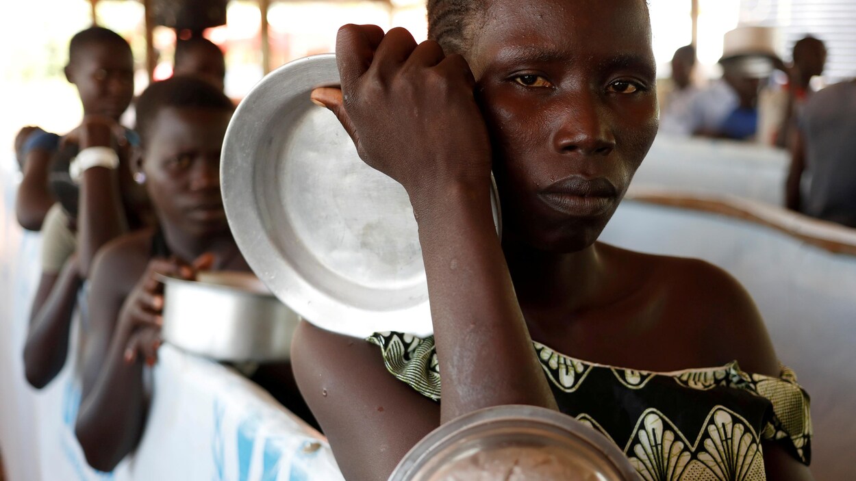 Des femmes attendent, écuelle en main