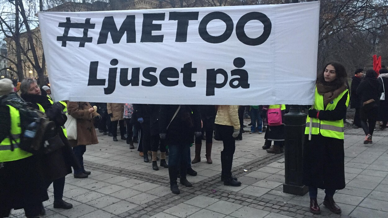 Deux femmes tiennent une affiche sur laquelle on peut lire #Metoo.