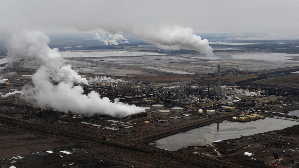 Vue aérienne des installations d'extraction des sables bitumineux de Syncrude avec celles de Suncor en arrière-plan, près de Fort McMurray, en Alberta.