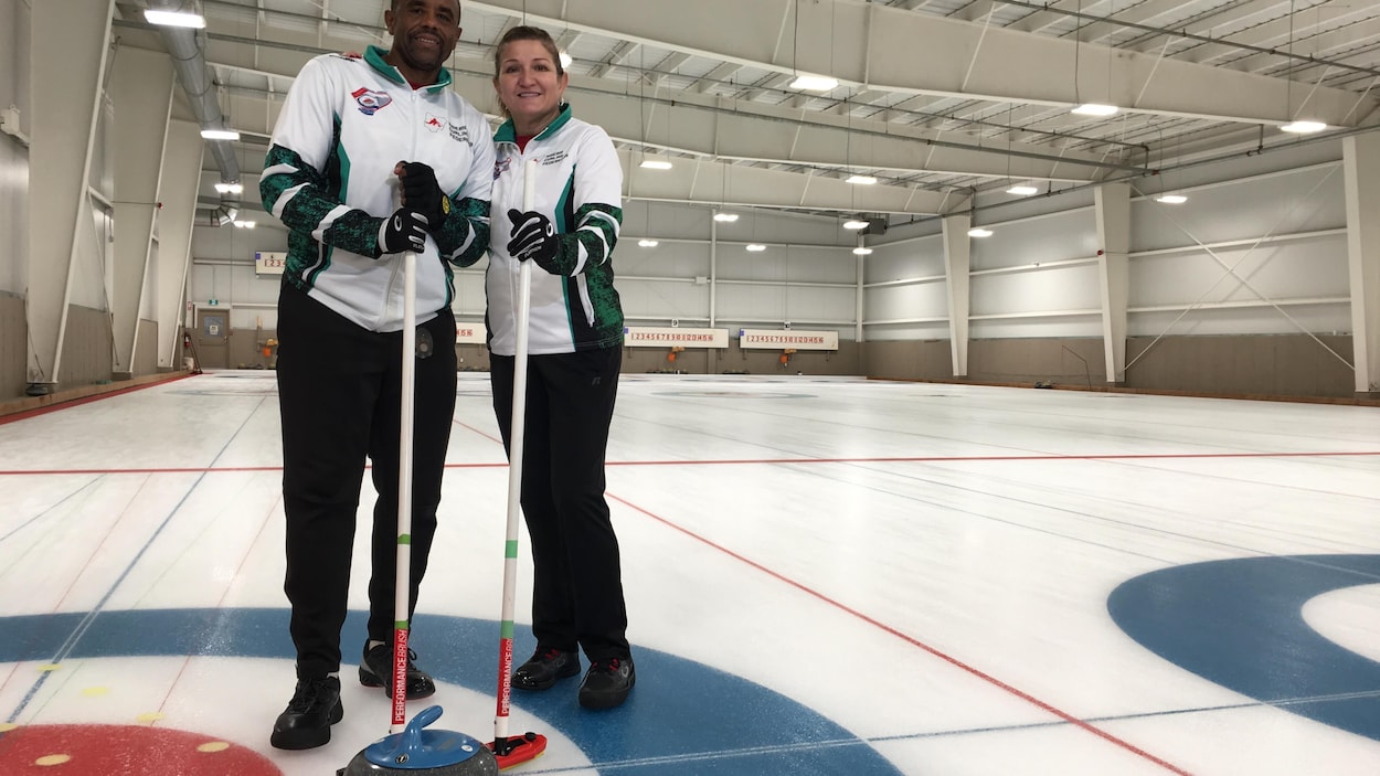 deux joueurs de curling sur une patinoire de curling