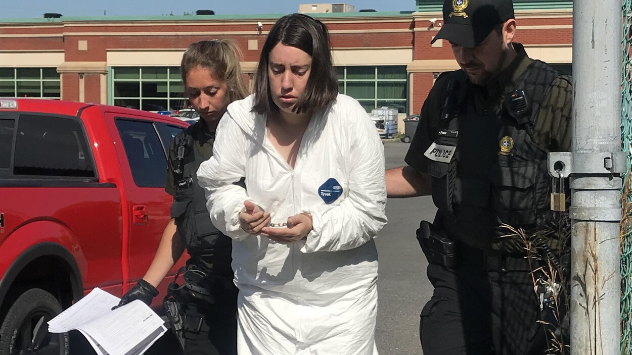 La suspecte escortée par deux agents de police.
