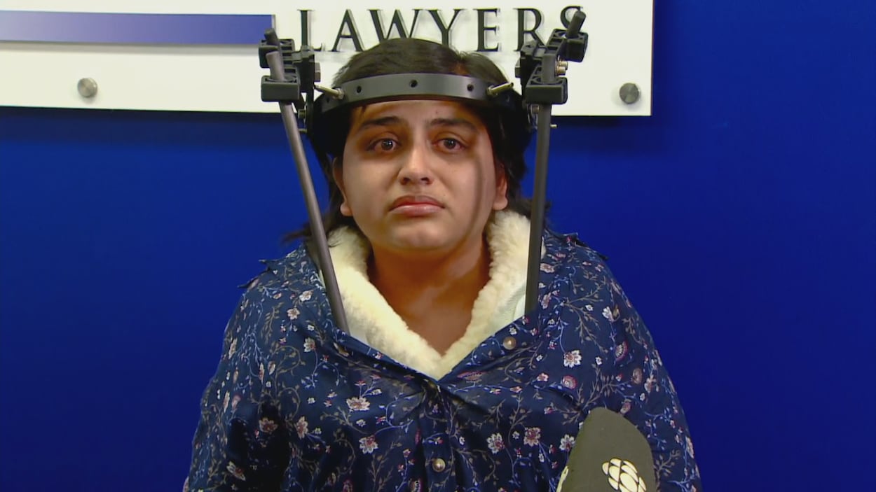 Sweta Patel lors d'une conférence de presse. Elle porte une armature pour stabiliser son cou et sa tête.