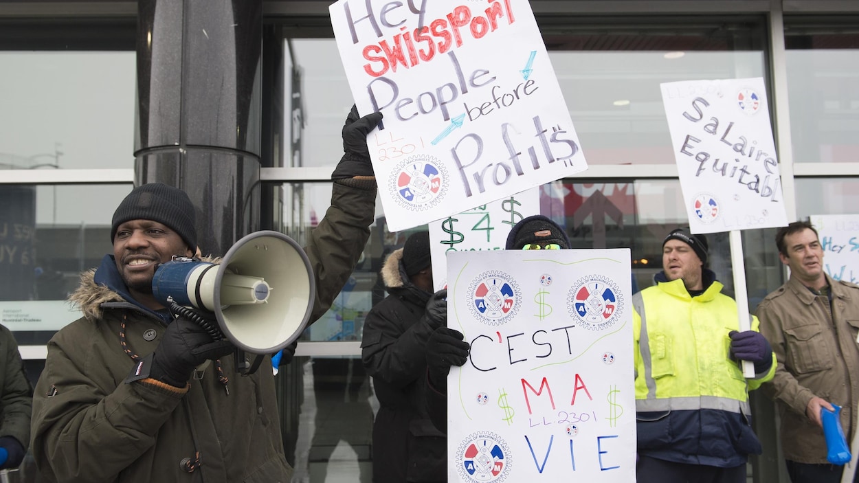 Des grévistes brandissent des pancartes.