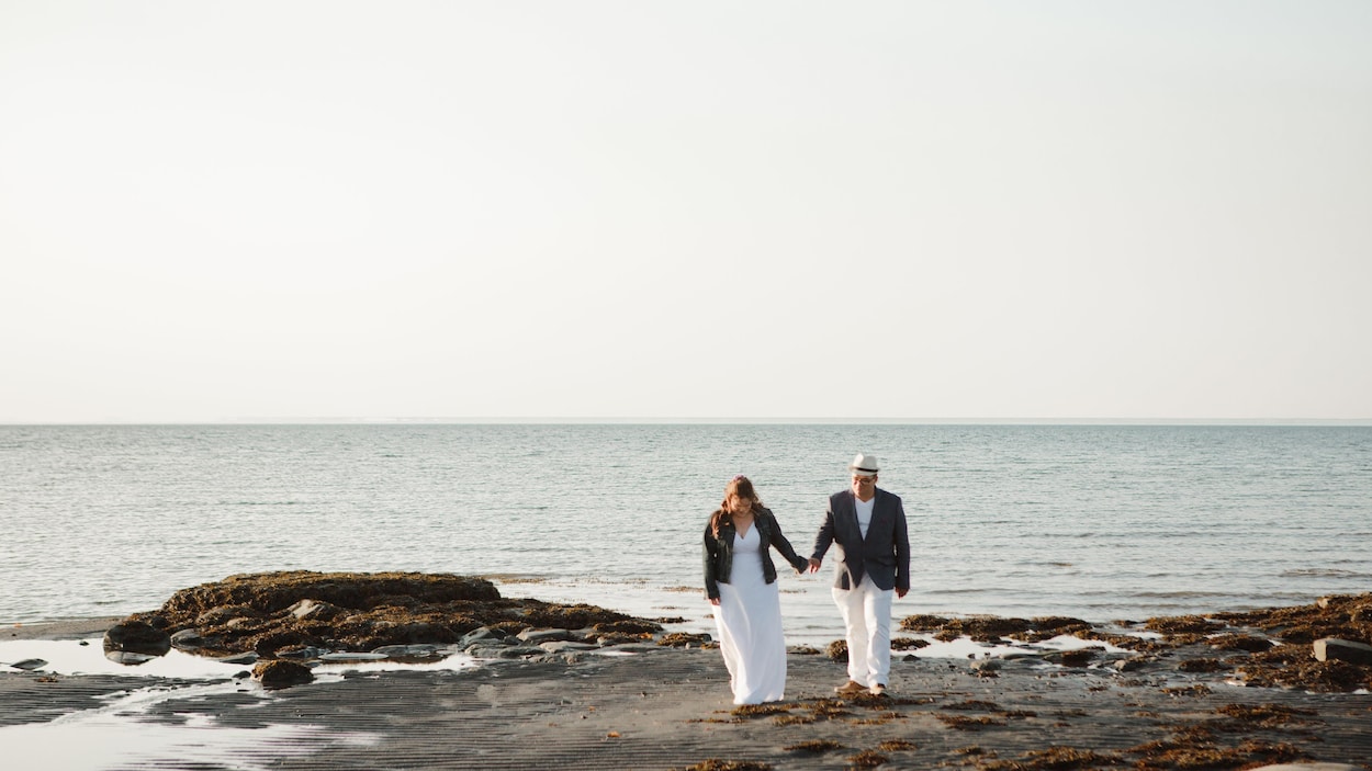 Le couple se tient la main devant le fleuve.