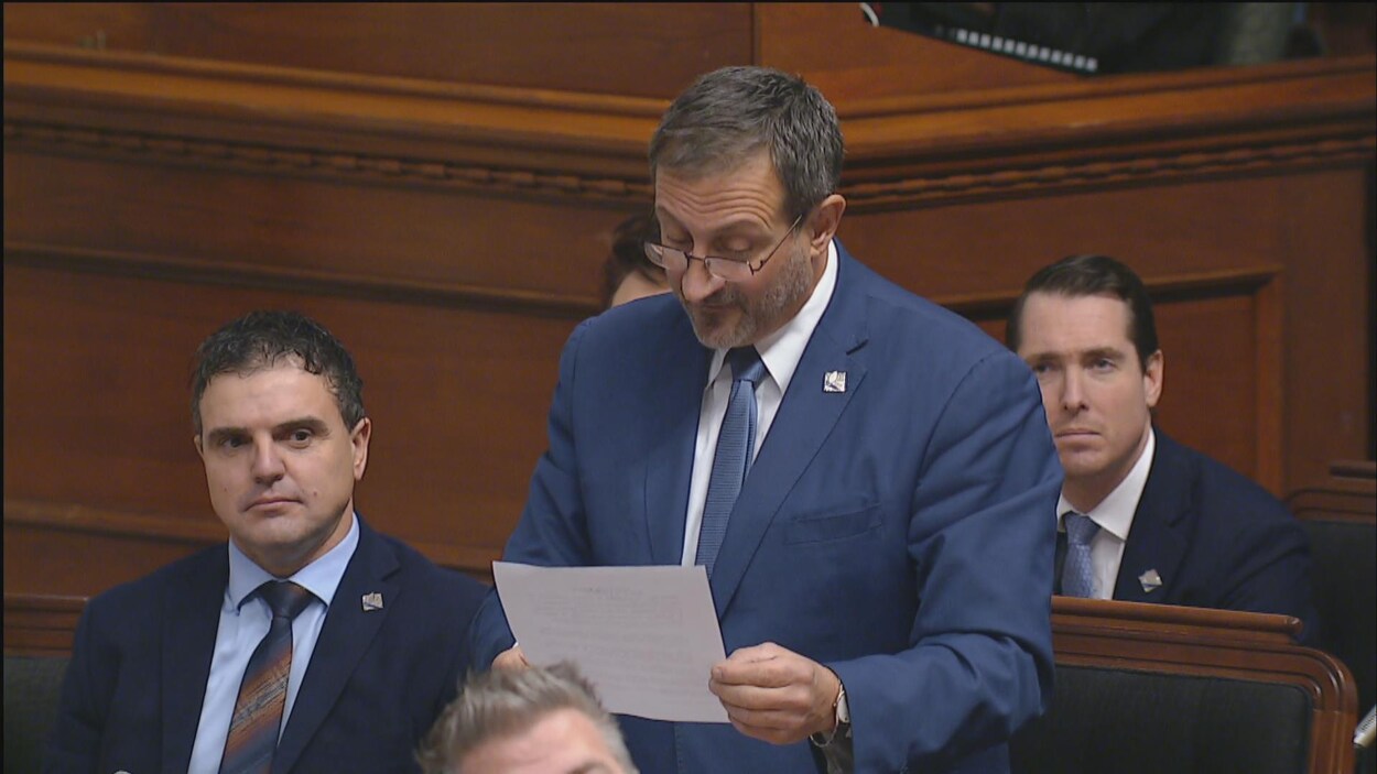 Un homme, debout, lit un document