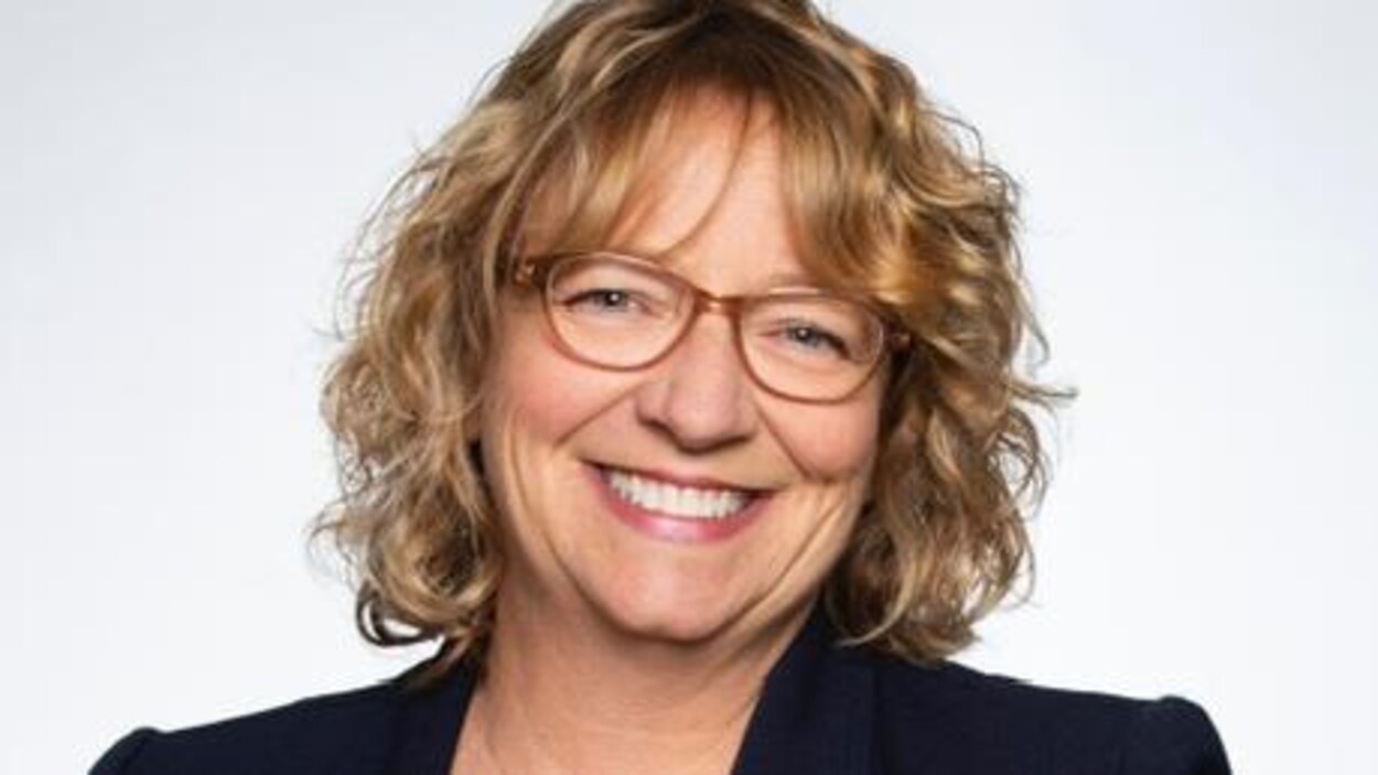 Sylvie Goneau pose comme candidate conservatrice devant un fond blanc.
