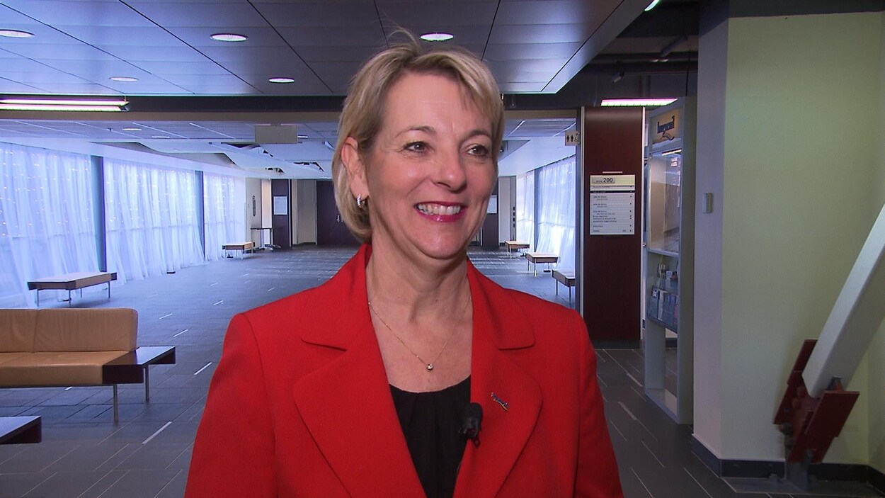 Sylvie Parent, tout sourire, portant un veston rouge.