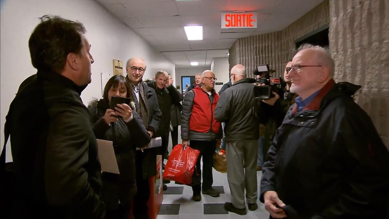 Plusieurs personnes dans un corridor.