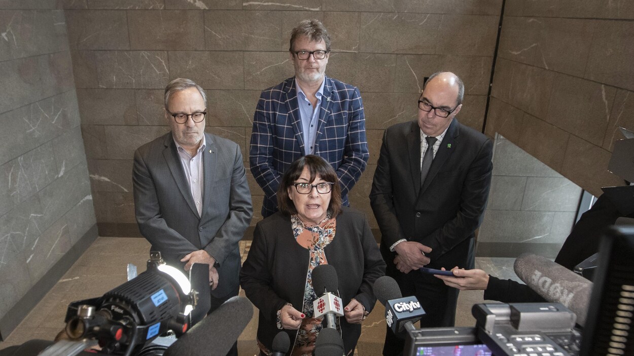 Plan en plongée des présidents de la FTQ, de la CSN et de la CSD, Daniel Boyer, Jacques Létourneau et Luc Vachon, ainsi que la présidente de la CSQ, Sonia Éthier, dans un lobby d’hôtel.