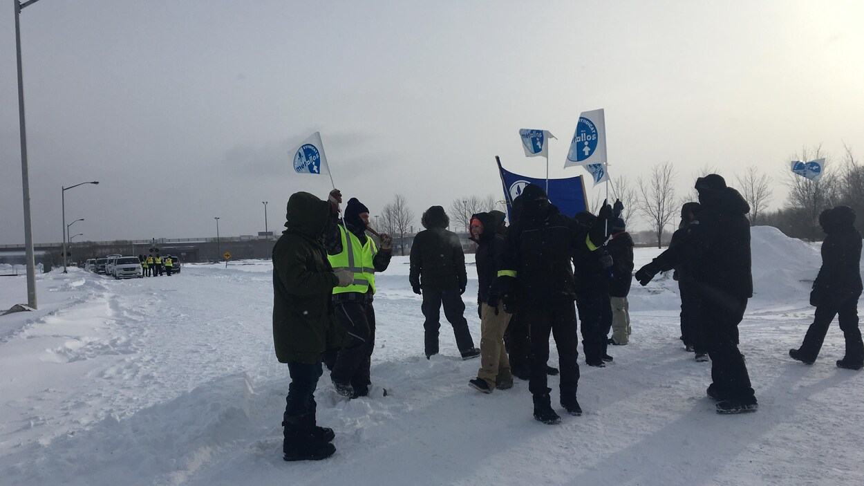 Des travailleurs en grève agitent des drapeaux. Des travailleurs en grève agitent des drapeaux.