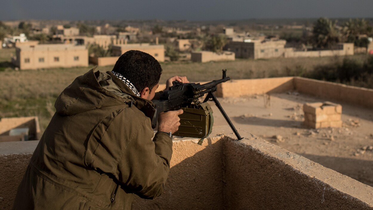 Un soldat pointe son arme vers une ville.