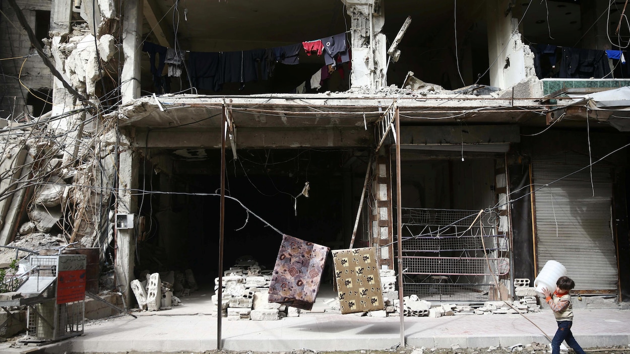 Un garçon marche près de maisons en ruine dans la Ghouta orientale. Un garçon marche près de maisons en ruine dans la Ghouta orientale.