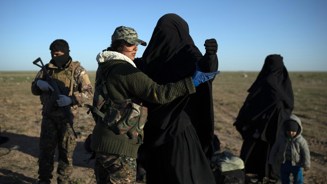 Une membre des Forces démocratiques syriennes fouille une femme qui a été évacuée de la dernière zone sous contrôle de l'État islamique, en Syrie.