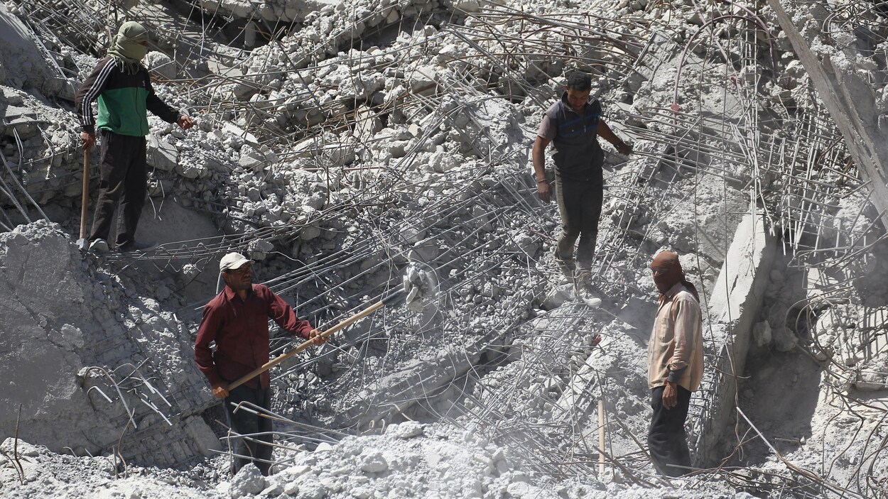 Des travailleurs creusent le sol à travers les ruines à Raqqa, le 18 avril 2018. Des travailleurs creusent le sol à travers les ruines à Raqqa, le 18 avril 2018.