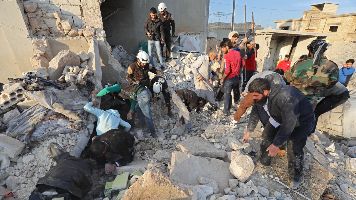 Des Syriens cherchent dans des ruines.
