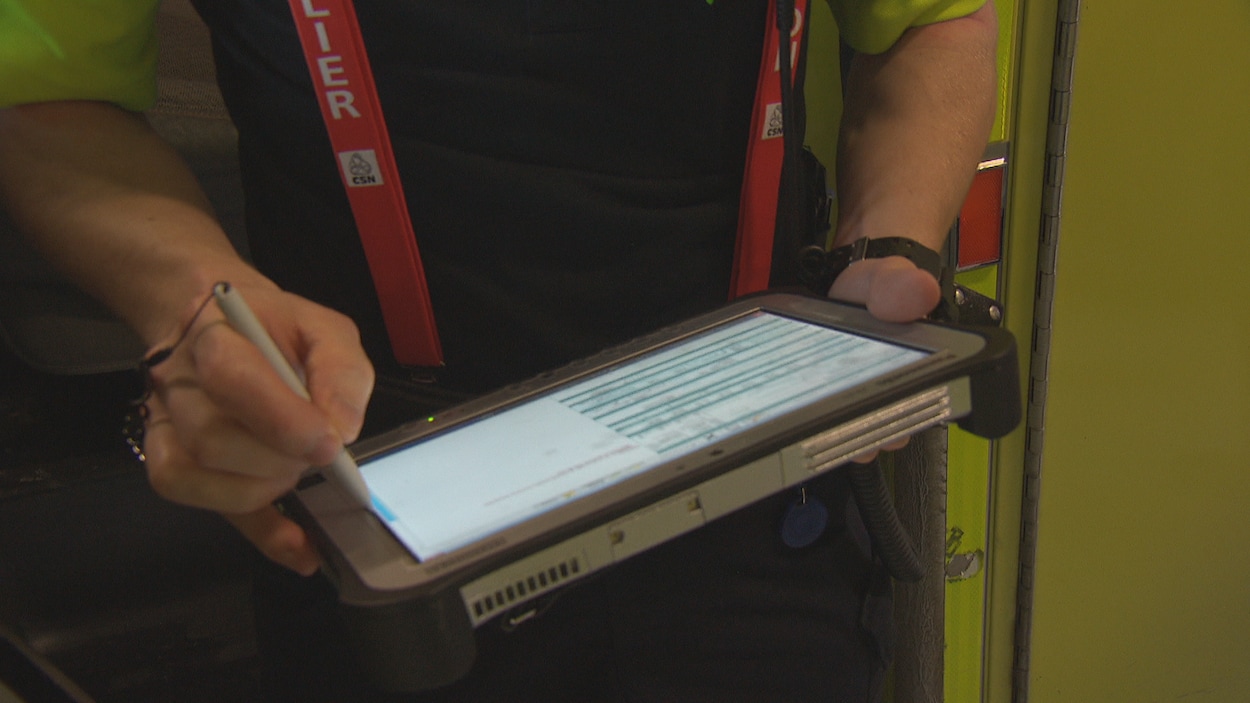Un ambulancier tient une tablette électronique