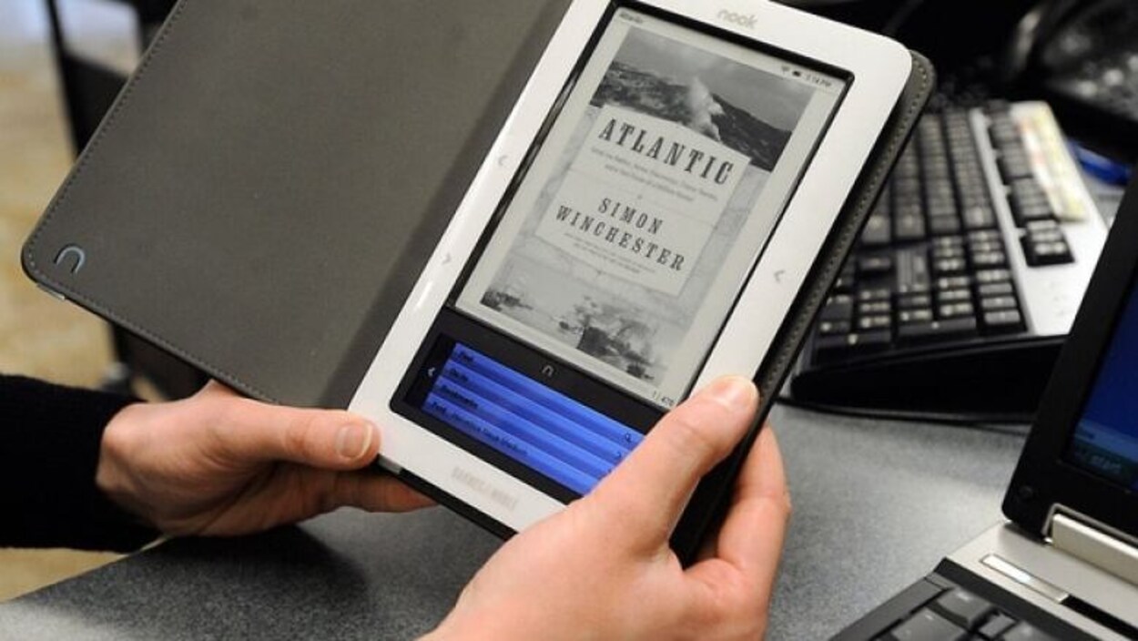 Une personne tient un livre électronique.